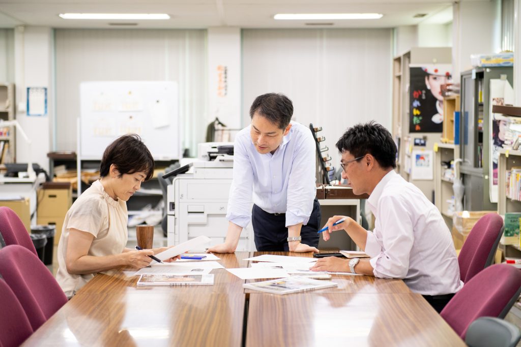 編集部にて打ち合わせをしている鈴木さん（画像中央・画像は鈴木さん提供）