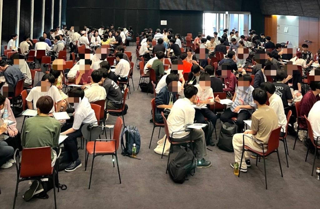 大きな部屋にたくさんの学生と卒業生がいる。
椅子に座り、4人程度のグループを作ってしゃべっている。